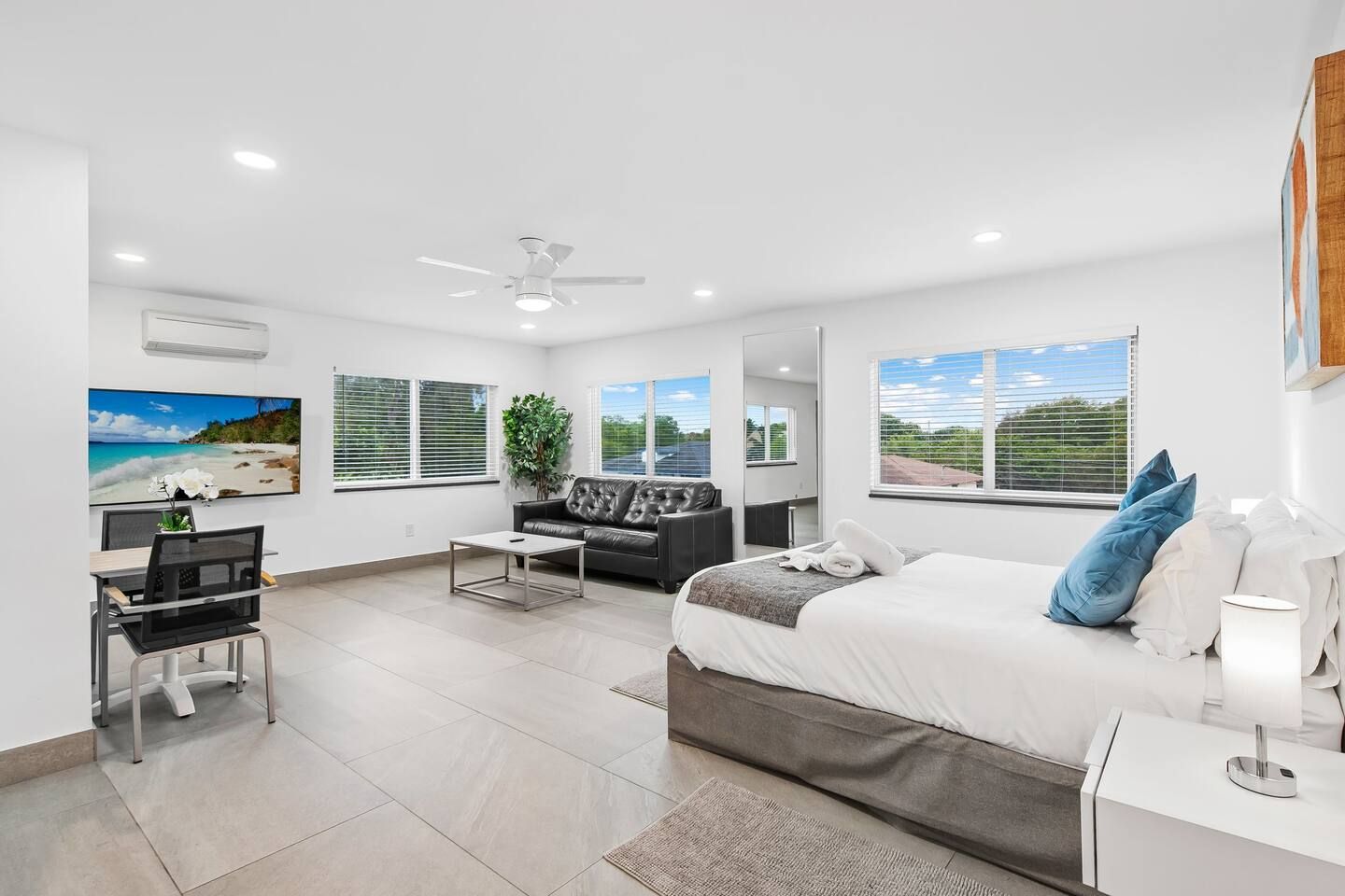 Une chambre d’hôtel moderne équipée d’un lit, d’un bureau et d’un coin salon.