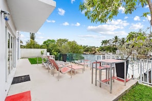 A rooftop terrace with outdoor seating and a view of the water.