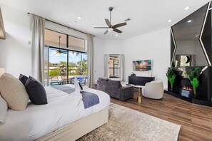 A modern hotel room with a bed, seating area, and a fireplace. - Spacious home w/pool & tennis court (Sunrise)