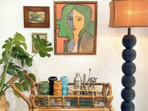 A room with a wooden coffee table, a potted plant, a framed painting, and a lamp. - 5 min to beach w/pool & BBQ (Fort Lauderdale)
