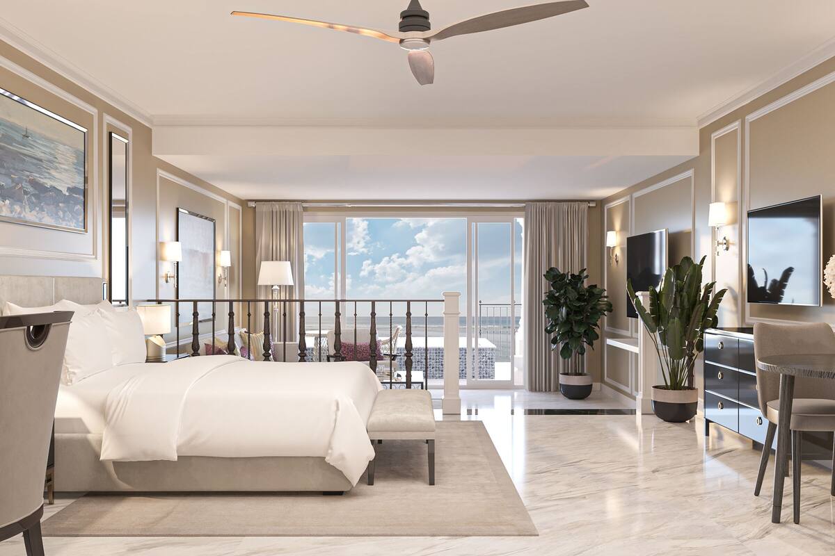 A spacious hotel room with a large bed, a ceiling fan, a balcony with a view of the city, and a TV mounted on the wall.