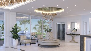 A luxurious lobby with a round seating area, large potted plants, and a view of palm trees through large windows. - The Grand Resort, Rarotonga (Rarotonga)