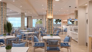 A spacious indoor dining area with multiple tables and chairs, a central bar, and a view of the ocean. - The Grand Resort, Rarotonga (Rarotonga)