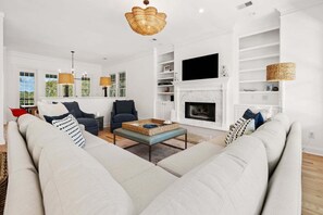 A living room with a sofa set, a coffee table, and a fireplace. - 5BR/5BA Retreat in Exclusive DeBordieu Colony (Georgetown)