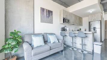 Suite Confort, balcón, vista a la ciudad | Área de sala de estar | Smart TV de 55 pulgadas con canales digitales y servicios de streaming
