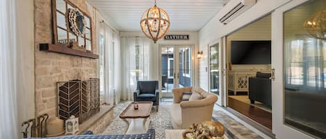 TV connectée, cheminée, livres, écrans d'ordinateur