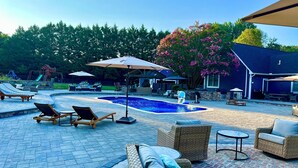 Ein Garten mit Schwimmbecken, Liegestühlen und Gartenmöbeln.