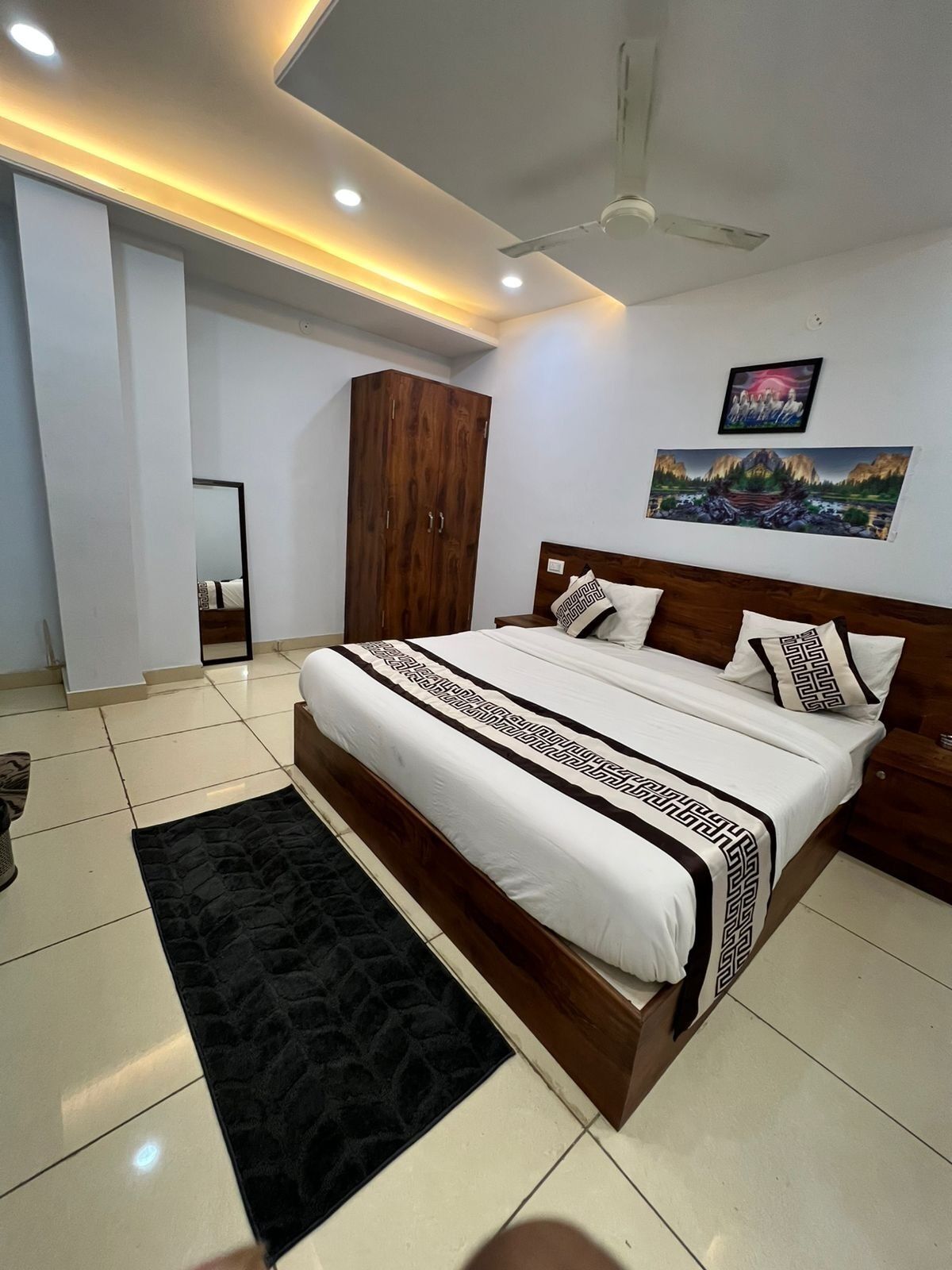 Quarto moderno com uma cama grande, um guarda-roupa, um ventilador de teto e um quadro na parede.