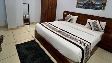 Quarto moderno com uma cama grande, um guarda-roupa, um ventilador de teto e um quadro na parede.
