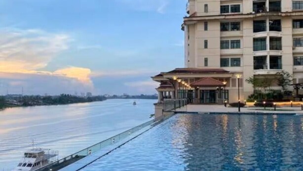 A high-rise hotel with a swimming pool extending to a waterfront. - Cozy Kuching Suite at Riverine Kuching (Kuching)
