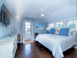 A bedroom with a bed, a TV, a ceiling fan, and a window with blinds. - Beautiful 5BR Northend Home • Sleeps 12 • Private Decks & Close to Beach (Ocean City)