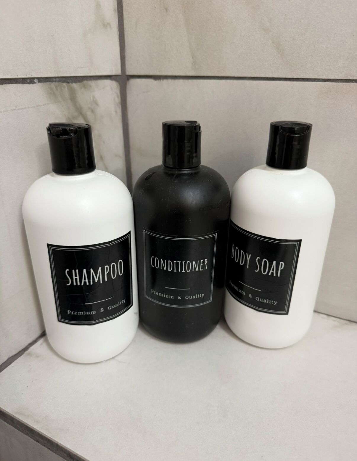 Trois bouteilles de produits d’hygiène personnelle sont posées sur une étagère.