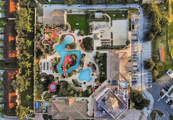 An aerial view of a resort with multiple swimming pools, a tennis court, and a parking area. - 4B/3B townhome close to Disney! Onsite pools, hot tubs, gym & restaurant! (Davenport)
