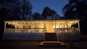 A two-story house with a covered porch and a staircase leading to the entrance. - Big Water Views, Private Dock, 7 Kayaks, Sleeps 12 (Sparta)