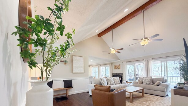 A spacious living room with wooden flooring, a large plant, and two ceiling fans. - Big Water Views, Private Dock, 7 Kayaks, Sleeps 12 (Sparta)