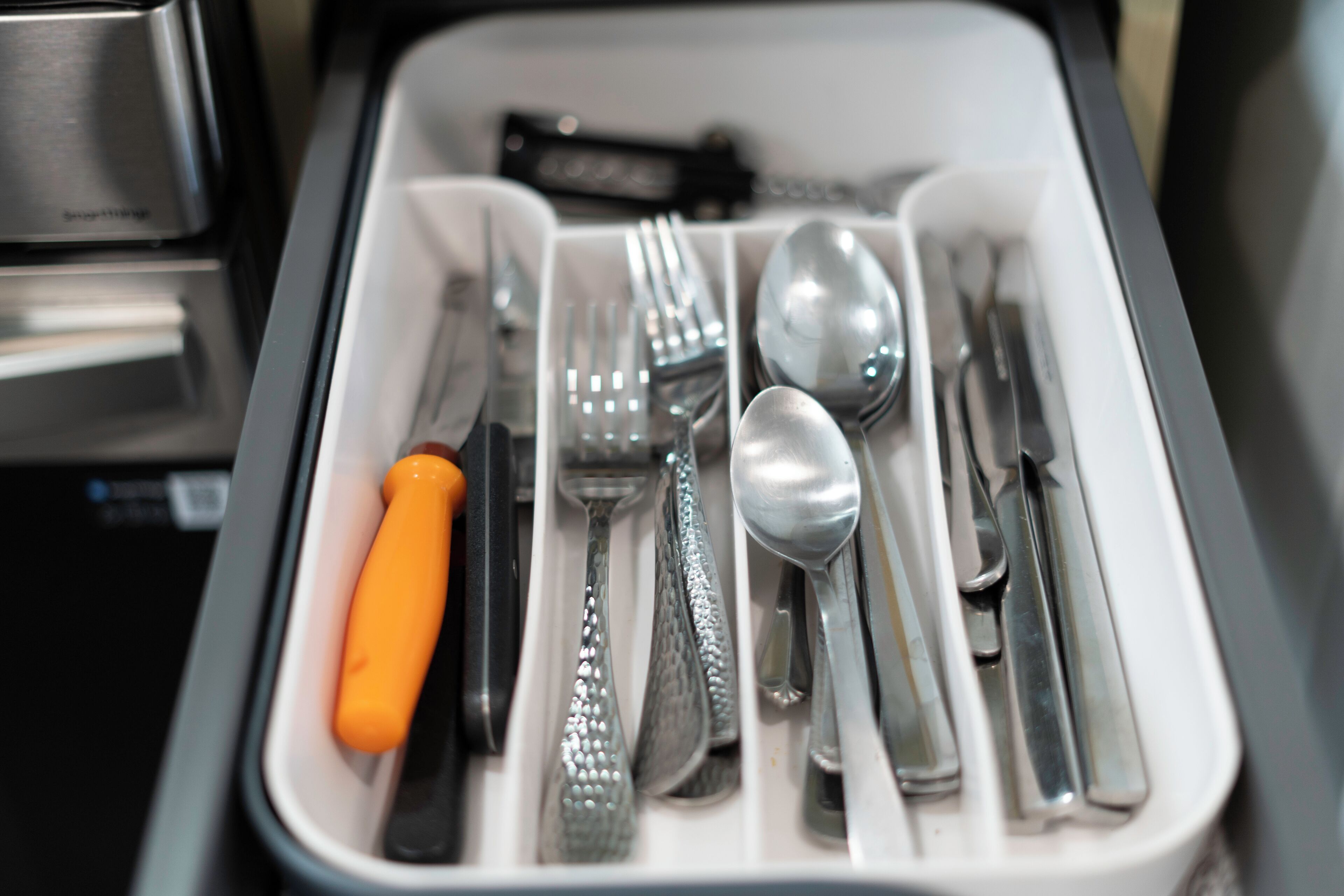 A drawer containing various utensils including forks, spoons, and knives.