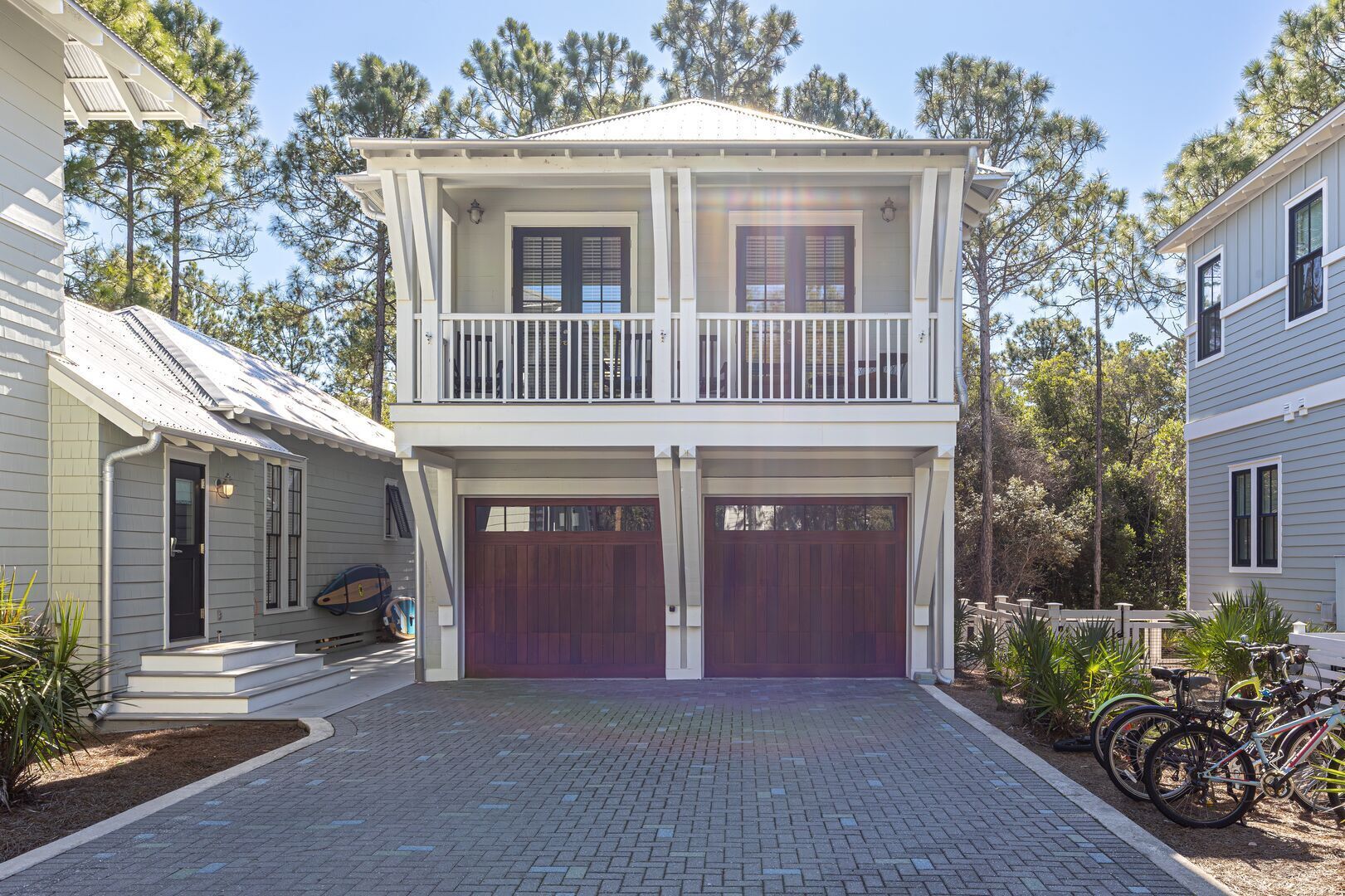 A two-story house with a front porch, two garage doors, and a driveway.