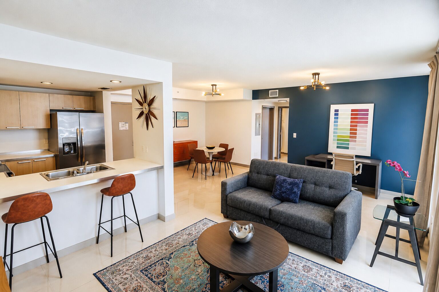 Un appartement moderne comprenant une cuisine, un coin repas et un salon.