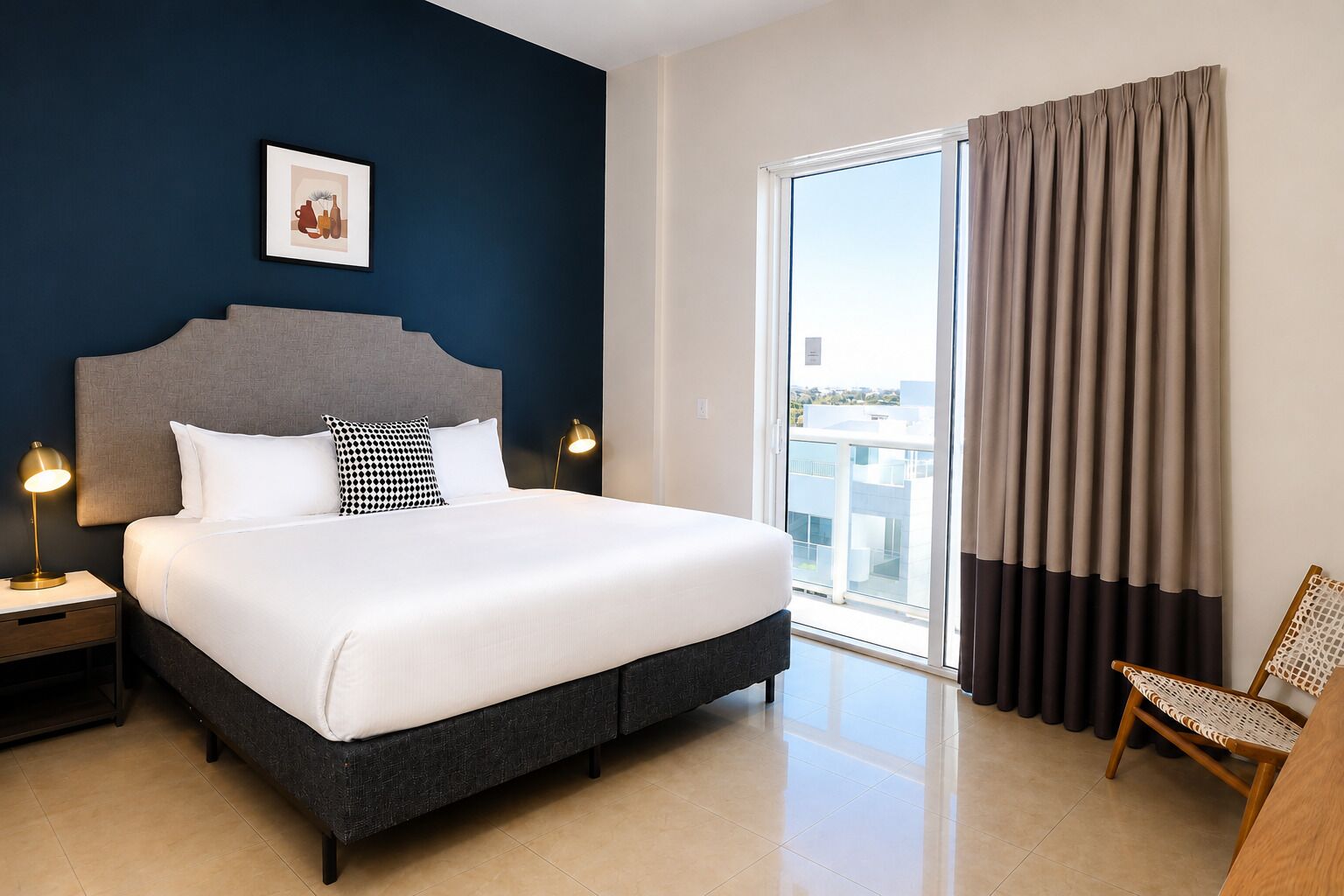 Une chambre d’hôtel avec un lit, une table de chevet, une chaise, une fenêtre avec des rideaux et un tableau encadré au mur.