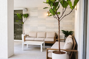 Una sala de estar moderna con un sofá, una mesa de centro y plantas en macetas.