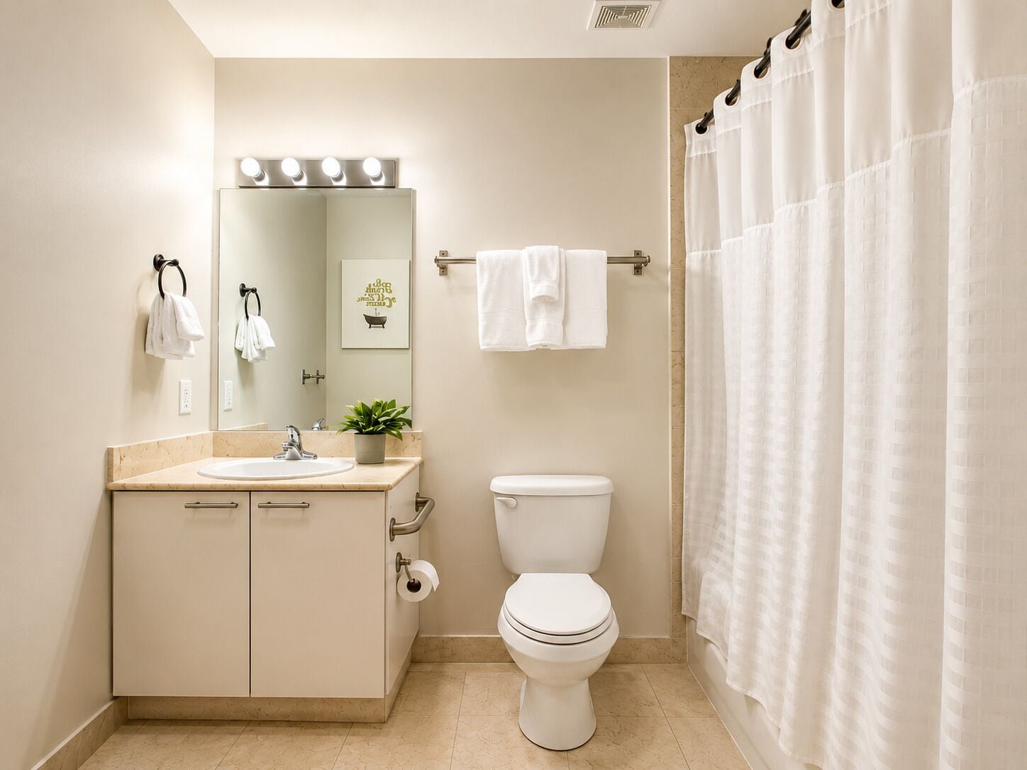 Een badkamer met een wastafel, spiegel, toilet en douchegordijn.