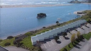 A coastal view with a parking lot and a building with a green roof.