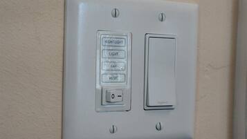 Eine an der Wand montierte Bedienkonsole mit Lichtschalter und einer Taste mit vier Optionen: NACHT, LICHT, VENTILATOR, MUSIK.