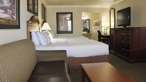 A hotel room with two beds, a sofa, a wooden table, a TV, and a dresser. - Baymont by Wyndham McAlester Hwy 69 (McAlester)