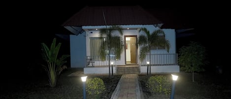 A small, single-story building with a tiled entrance and a pathway leading to the door.