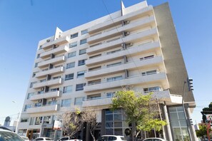 A multi-story building with balconies, large windows, and a flat facade.