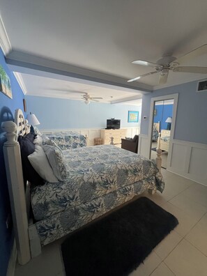 A bedroom with a bed, a ceiling fan, a dresser, and a television. - Blue Sea Hideaway ~Perfect For Two 1-bedroom studio in quiet East End (East End)
