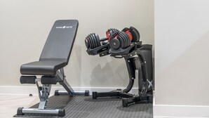 Ein Fitnessraum mit einer Bank und einer Hantelbank.