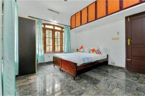 A bedroom with a bed, a wardrobe, a window, and a door.