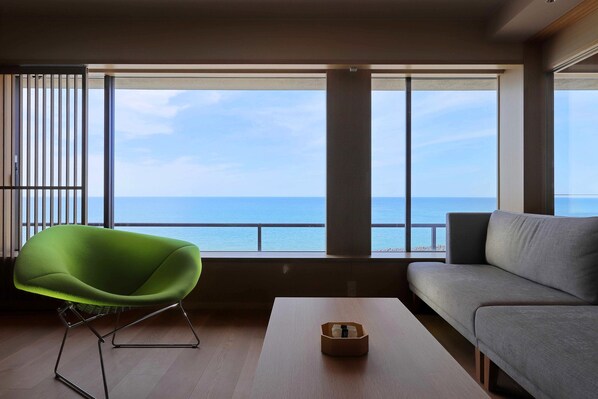 Una sala de estar moderna con un sillón verde, un sofá gris y una mesa de centro de madera.