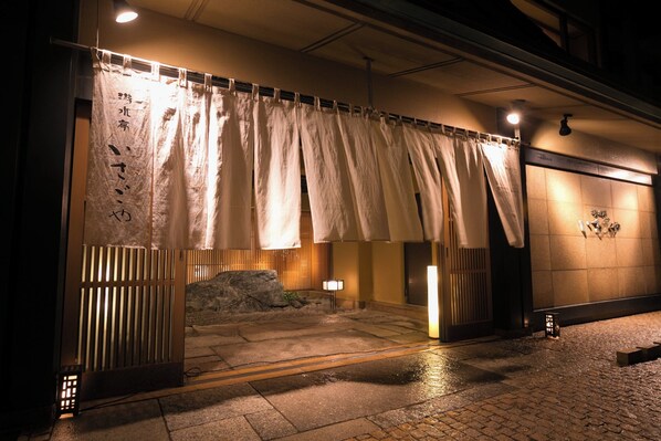 A traditional Japanese entrance with sliding doors, a stone pathway, and a small rock garden. - yuusuiteiisagoya (Tsuruoka)