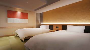 A hotel room with two beds, a wooden headboard, and a wall-mounted artwork.