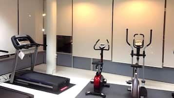 A gym with a treadmill, an elliptical, and a stationary bike.