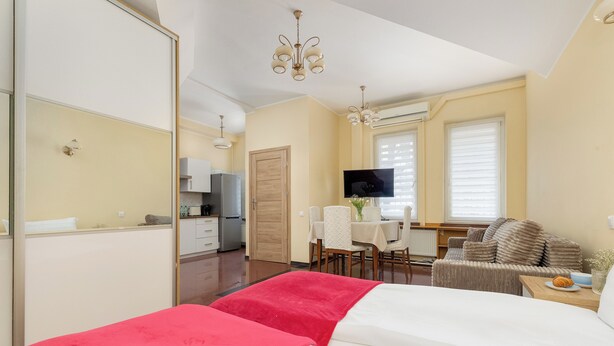 Une chambre d’hôtel équipée d’un lit, d’un bureau, d’une chaise, d’une télévision et d’une kitchenette.