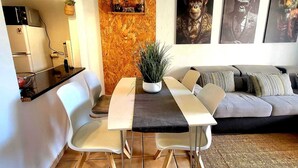 A modern living room with a dining table, sofa, and artwork on the wall. - CHABELLA! Charm Beach Lofts Apartments - Garden & Sea View - CARVOEIRO - ALGARVE (Carvoeiro)