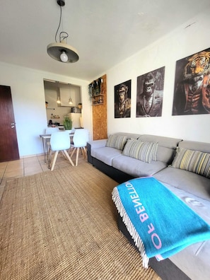 Un salon moderne comprenant un canapé, une table basse et un coin repas avec des chaises et une table.