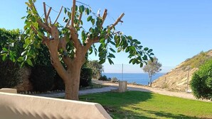 A pool area with two sun loungers, a tree, and a view of the sea. - CHABELLA! Charm Beach Lofts Apartments - Garden & Sea View - CARVOEIRO - ALGARVE (Carvoeiro)
