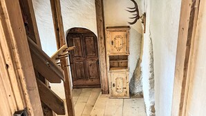 Eine Holztreppe führt zu einem Raum mit einer Holztür und einem Schrank.