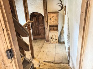 Una escalera de madera que conduce a una habitación con una puerta y un armario de madera.