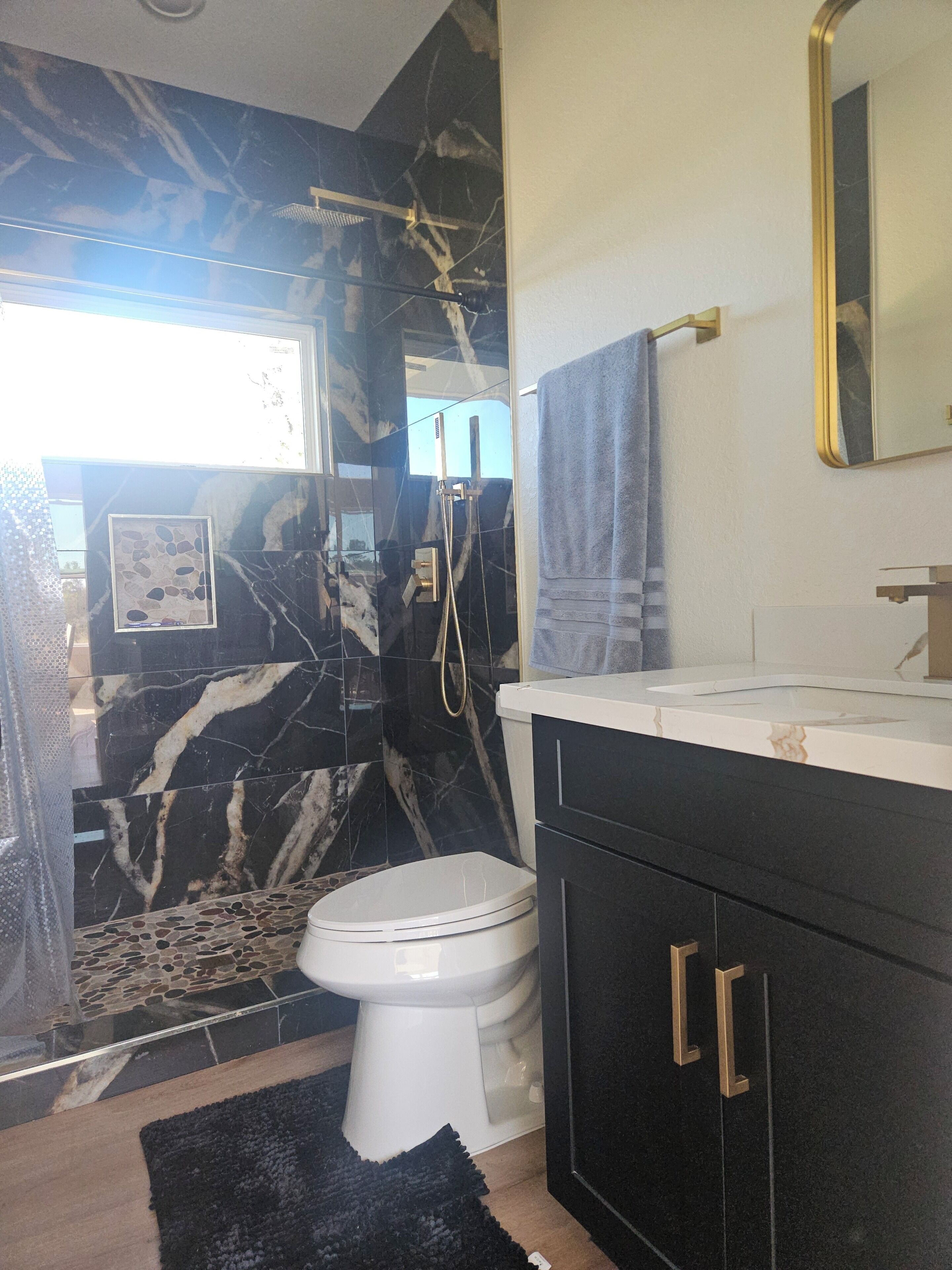 A bathroom with a toilet, a shower, and a sink.