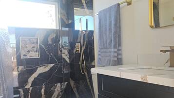 A bathroom with a toilet, a shower, and a sink.