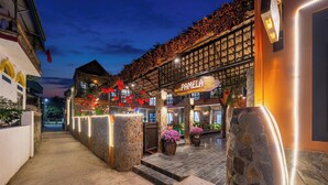 A hotel entrance with a stone facade, a sign reading "Pamela," and a covered walkway with red lanterns. - Tam Coc Pamela Homestay (Nam Hoa Lu)