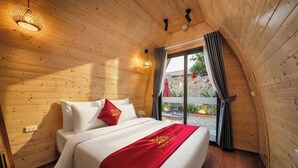 A wooden-paneled bedroom with a bed, pillows, and a red bedspread. - Tam Coc Pamela Homestay (Nam Hoa Lu)