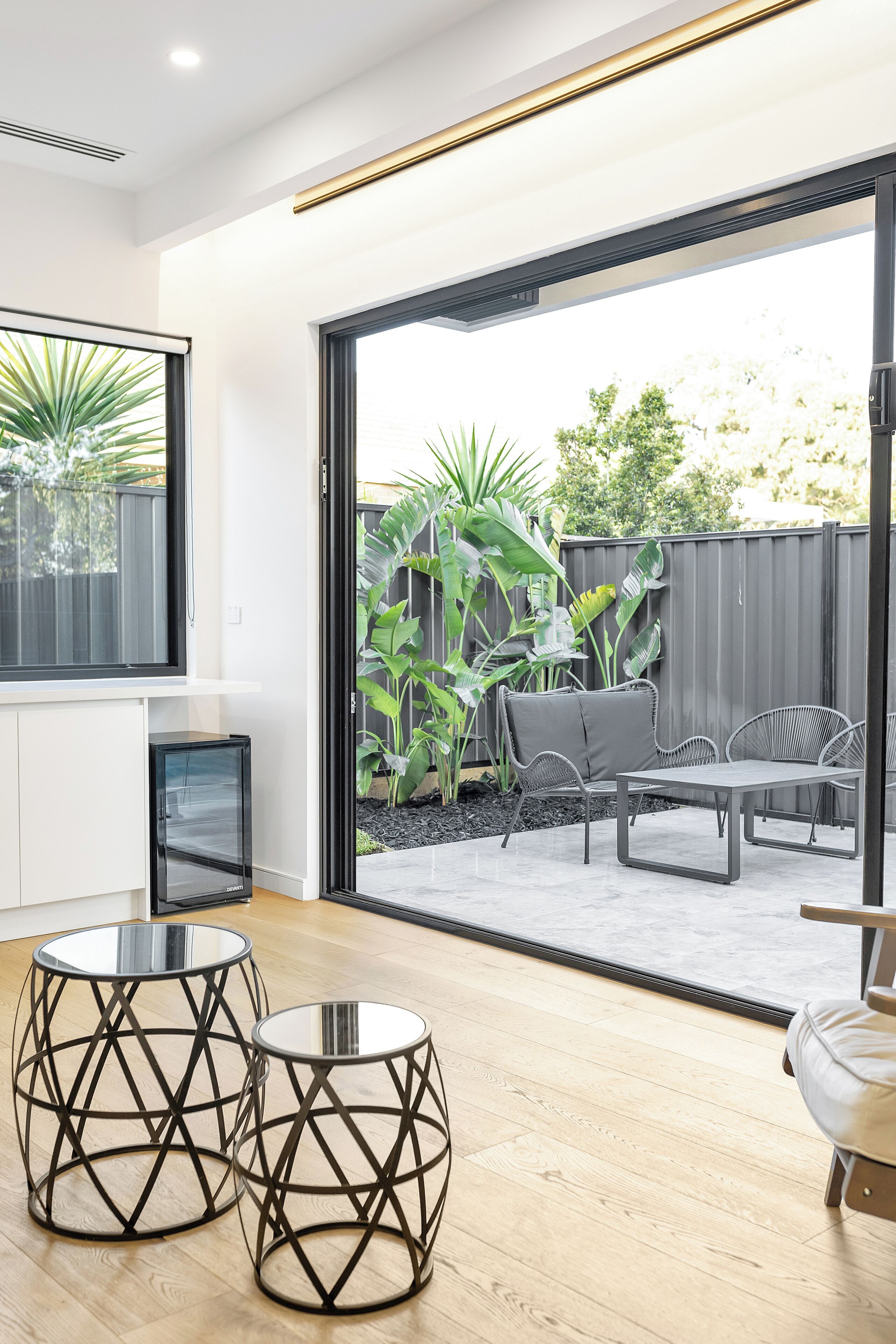 A modern living room with a large sliding glass door leading to an outdoor patio area.