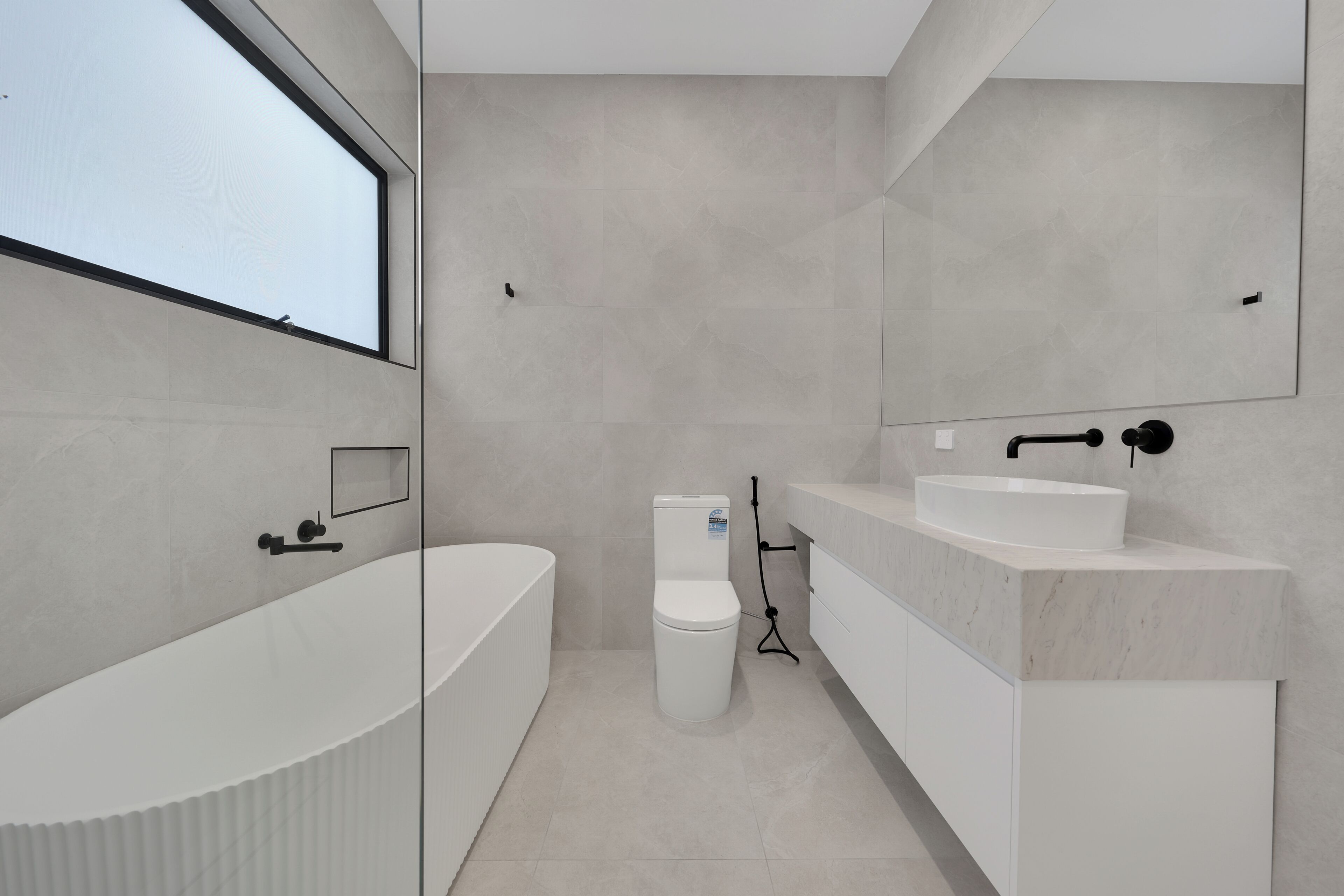 Une salle de bain moderne avec une baignoire sur pieds, des toilettes et un meuble-lavabo avec un évier.