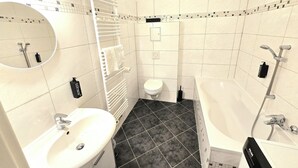 A bathroom with a sink, toilet, and bathtub. - Spacious 75 sqm apartment with balcony and parking space (Chemnitz)